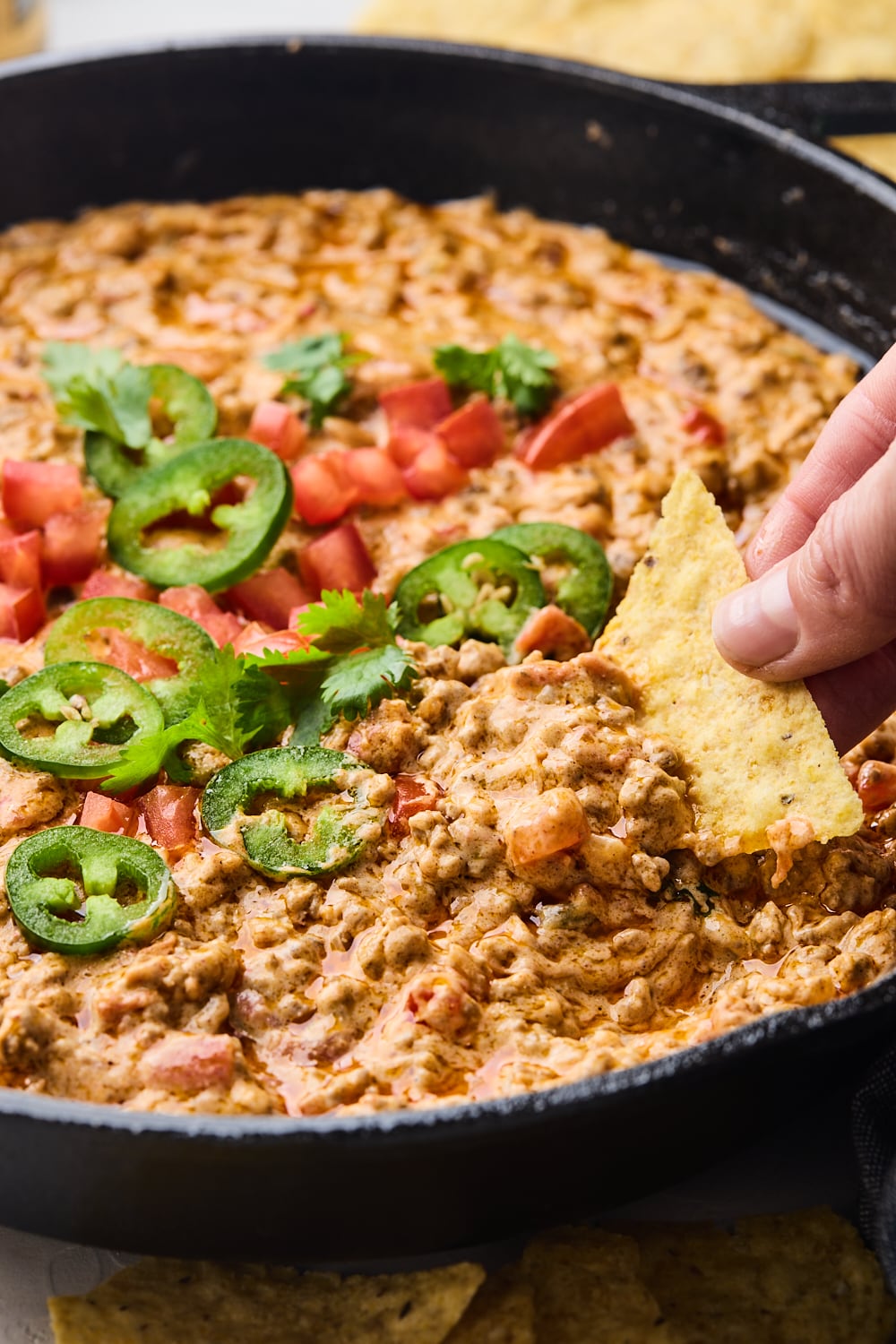 Easy Rotel Dip with a Nacho chip dipped in