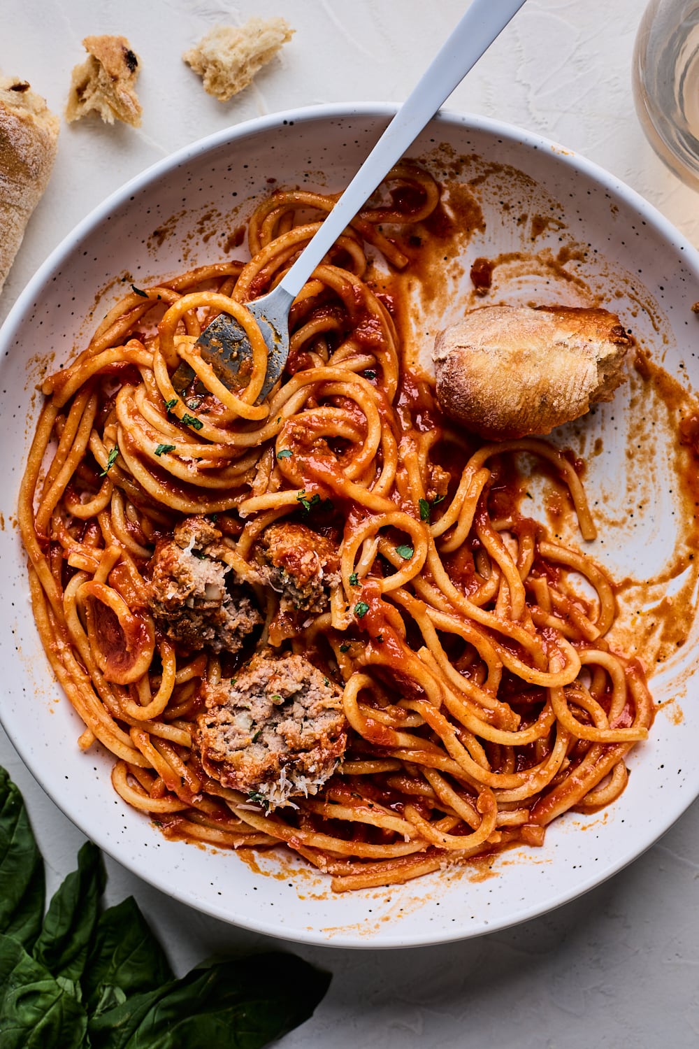 Spaghetti Meatballs half eaten on a plate with some bread dipped in