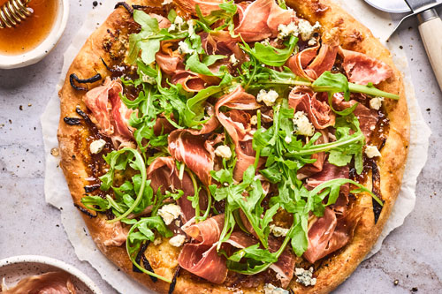 Fig Prosciutto Gorgonzola and Arugula Pizza With Hot Honey