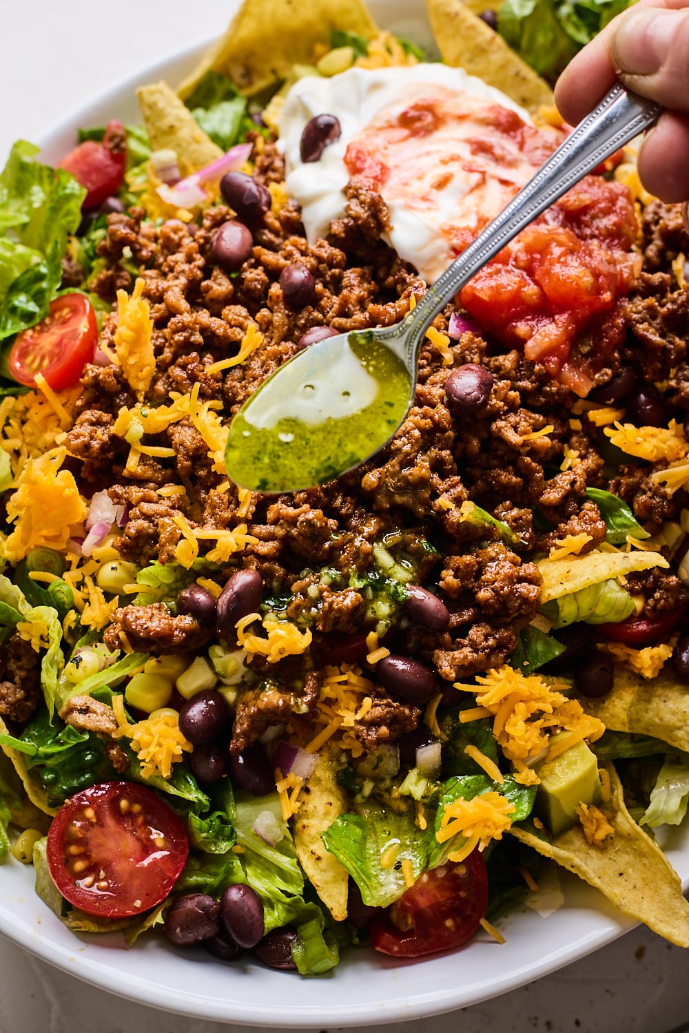 Taco Salad with dressing being poured on